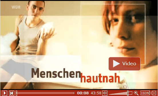 Ein angehaltenes Videobild, das einen Mann und eine Frau zeigt, mit dem Titel „Menschen Hautnah“ und dem Symbol für stumme Stimmen unten darübergelegt.