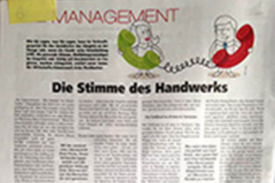 Unscharfes Bild eines Zeitungsartikels mit dem Titel „Management“ mit Abbildungen eines Mannes in einem Sessel und eines Telefons, begleitet von einem deutschen Text aus „Die Stimme des Handwerks“.
